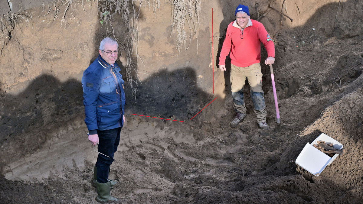 Dr. Christoph Reichmann, ehemaliger Leiter des Museums Burg Linn, und Stadtarchäologe Dr. Hans-Peter Schletter (r.) vor einem freigelegten Bereich des Grabens. Die roten Markierung wurde nachträglich für eine bessere Wahrnehmung in das Foto montiert. Foto: Stadt Krefeld, Presse und Kommunikation, Andreas Bischof