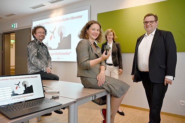 Krefelds Oberbürgermeister Frank Meyer (rechts) stellte gestern gemeinsam mit der Kulturbeauftragten Gabriele König (hinten), dem Schriftsteller Bernhard Hennen (links) und der Linner "Burgherrin" Jennifer Morscheiser den "Krefelder Preis für Fantastische Literatur" vor. Morscheiser hält das Originalexemplar des Pentagondodekaeders in Händen, das als Vorlage für die Trophäe dienen wird. Foto: Stadt Krefeld, Presse und Kommunikation, A. Bischof